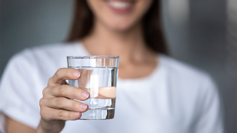 Frau hält ein Glas Wasser