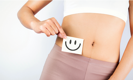 Frau hält einen Smiley vor ihren Bauch