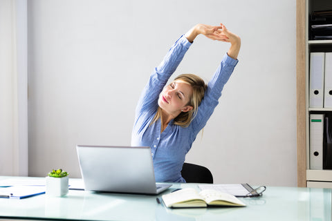 Frau dehnt sich im Büro