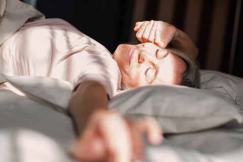 Eine Frau wacht erholt im Bett auf