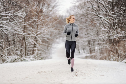 Eine junge Frau geht im Winter im Schnee joggen