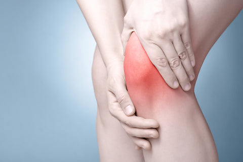 Person hält sich das Knie vor Schmerzen