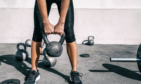 Frau trainiert mit einer Kettlebell