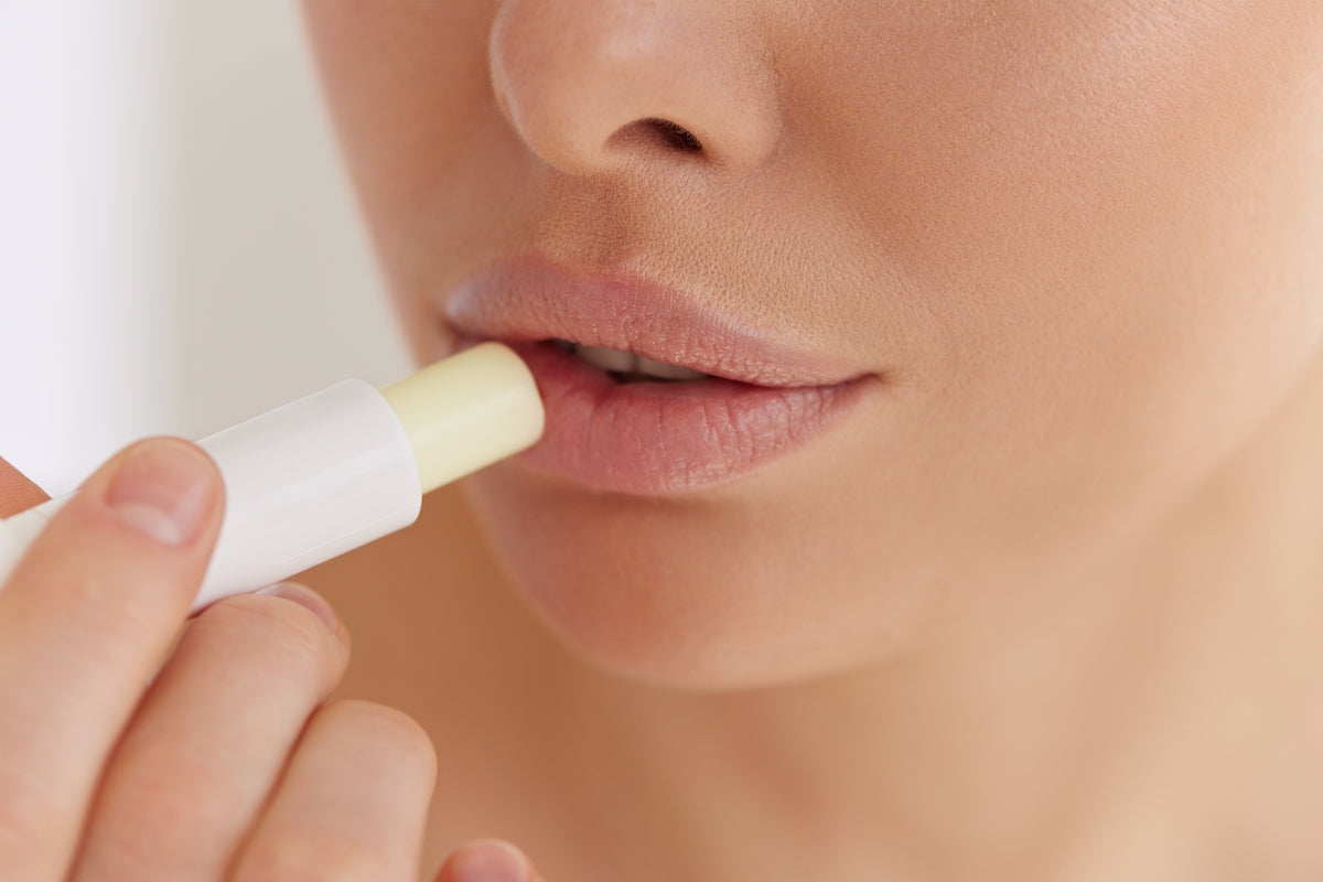 Frau benutzt Lippenpflege