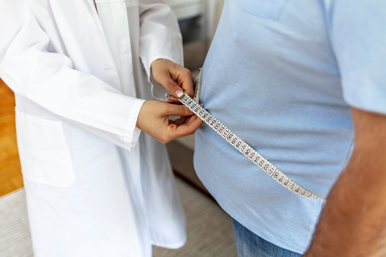 Arzt misst Bauchumfang eines Patienten