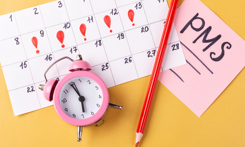 Kalender und Wecker, daneben Zettel PMS