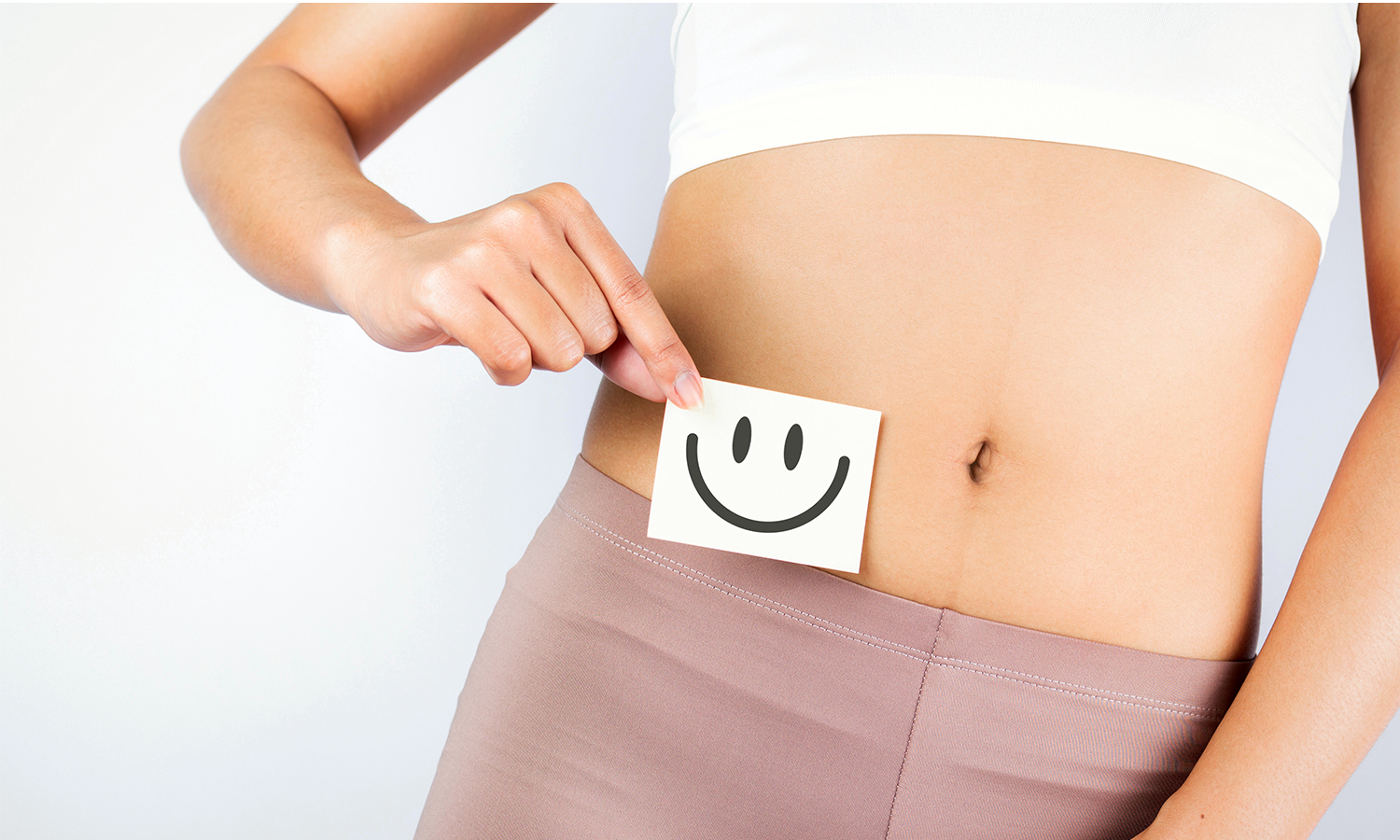 Frau hält sich Smiley vor den Bauch