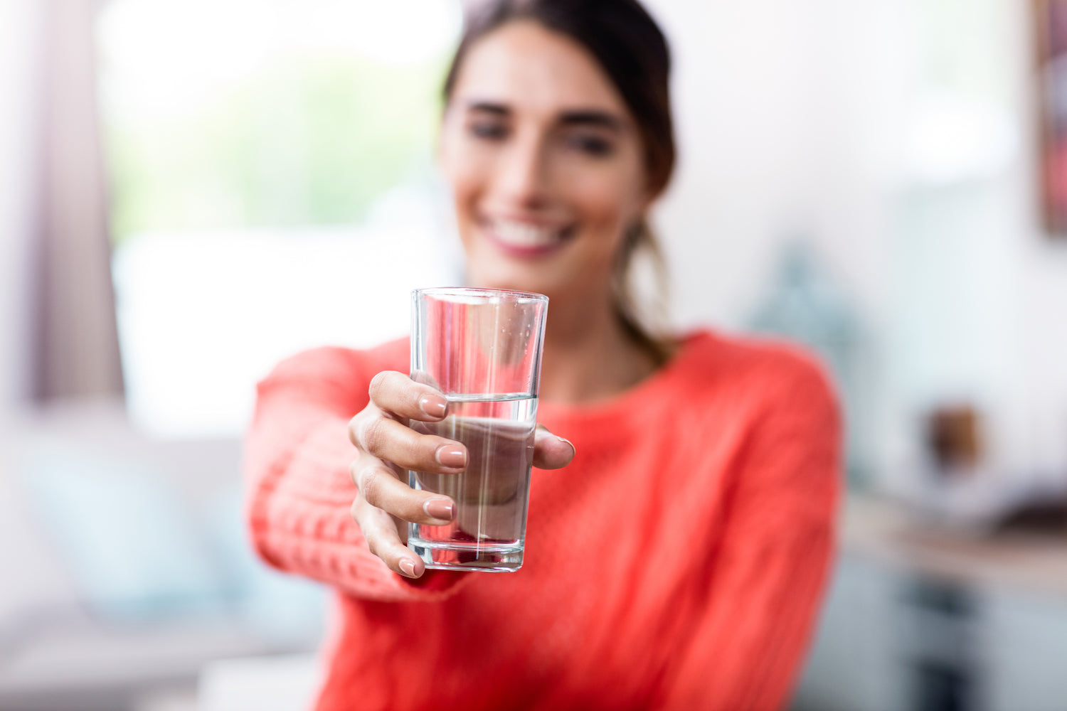 Frau hält ein Glas Wasser