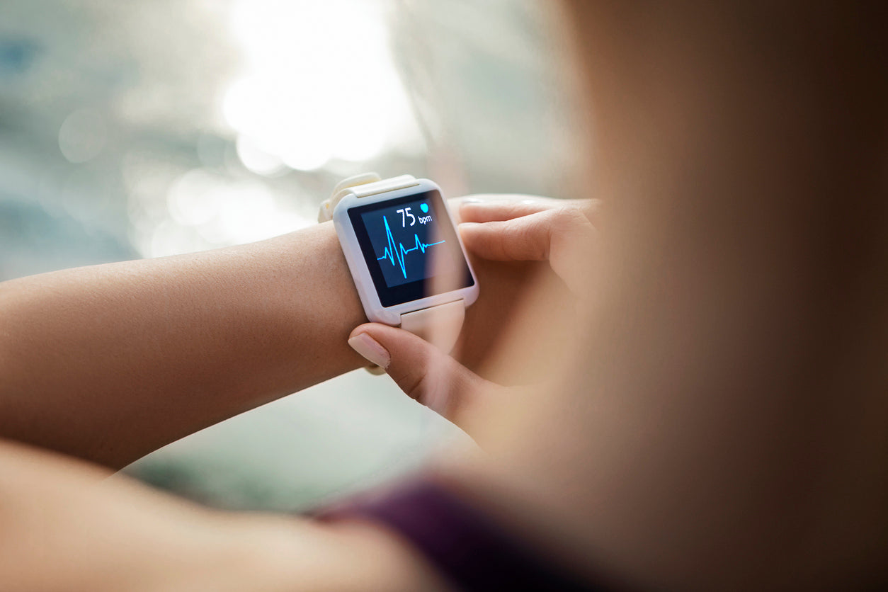 Fitness-Tracker Gesundheit: Frau schaut sich ihre Herzfrequenz auf ihrer Fitnessuhr an